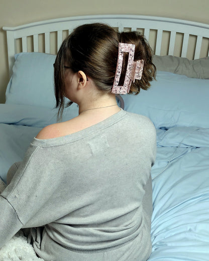 Emily XL claw clip in soft pink speckled acetate, worn in a ponytail and seen from behind